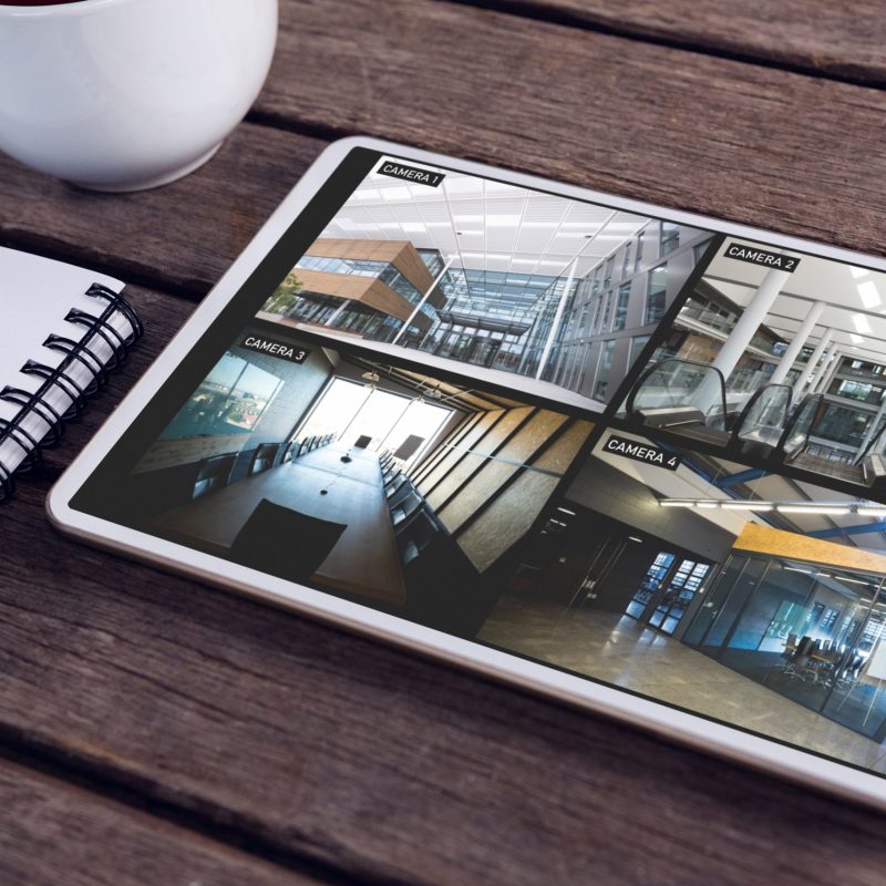 Tablet with views of offices from security cameras on screen lyi